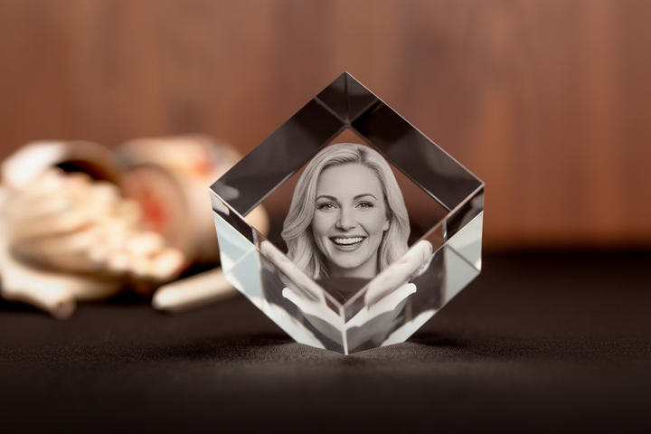 Crystal photo cube with a woman's face on a dark surface
