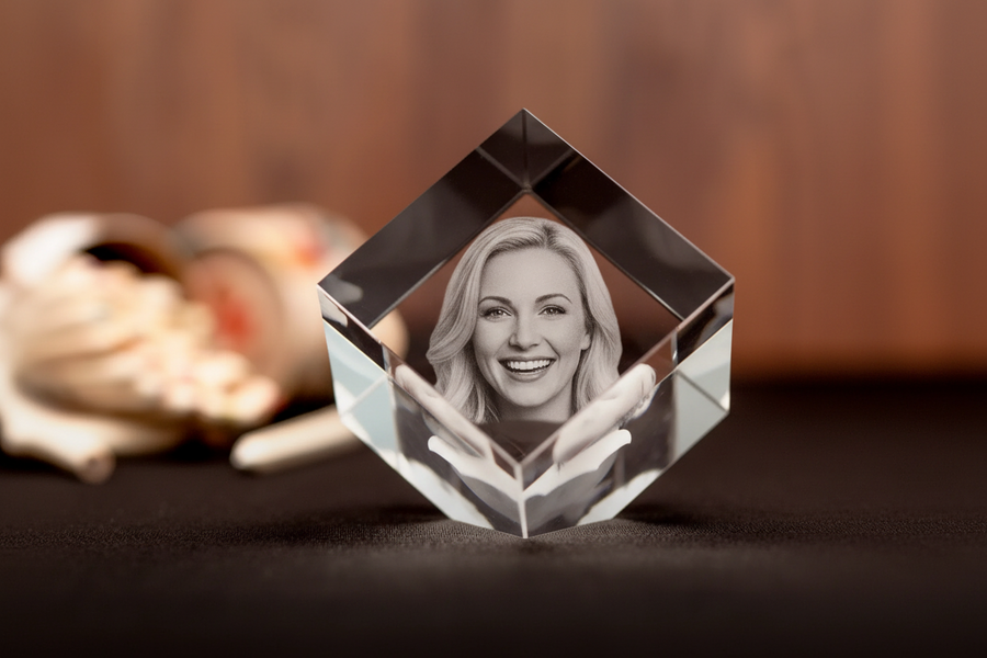 Crystal photo cube with a woman's face on a dark surface